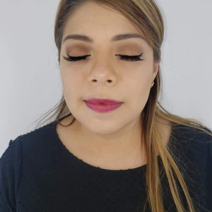 A woman with elegant eye makeup and vibrant pink lipstick, showcasing a beauty look for women over 40.