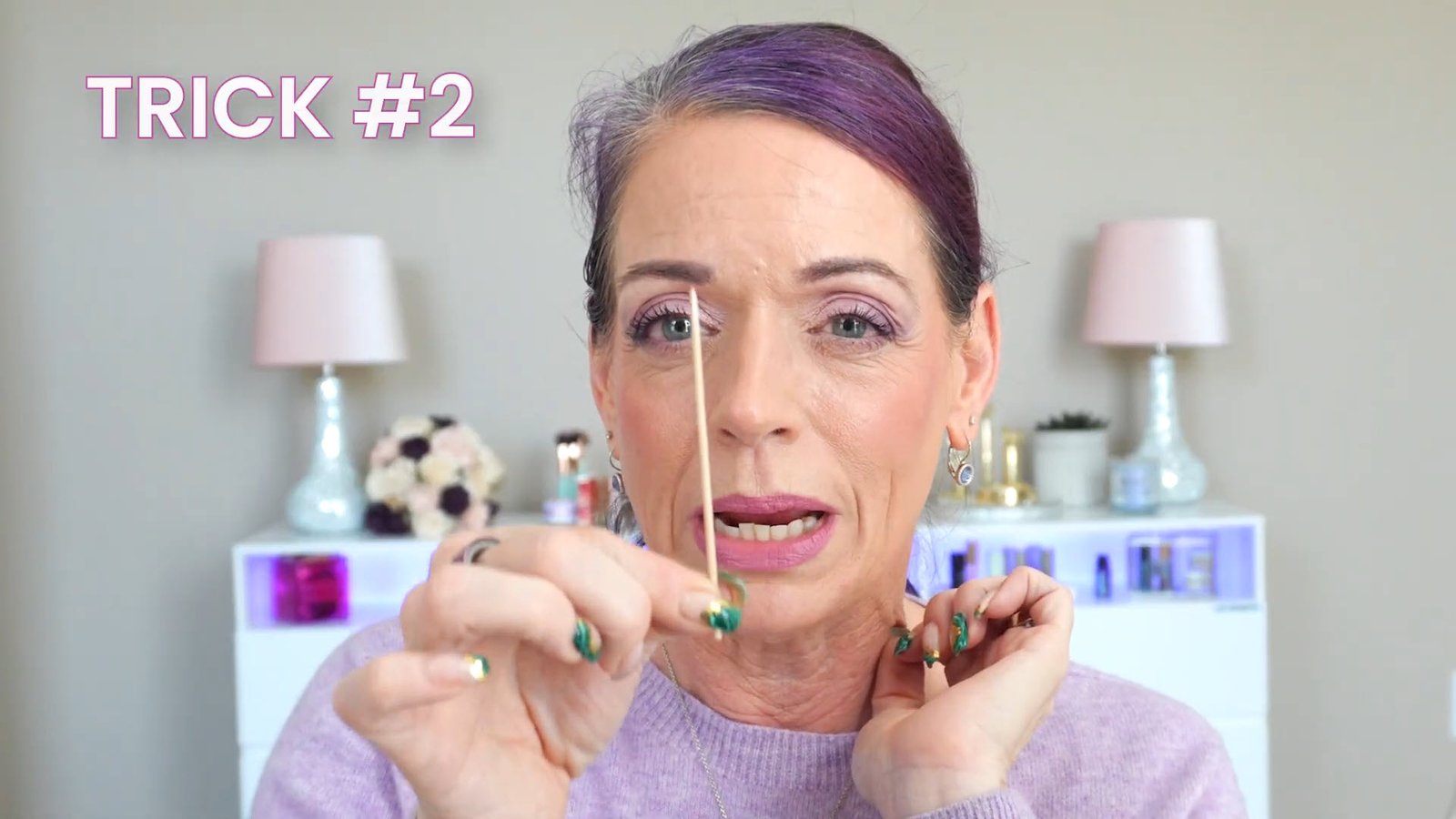 A makeup artist demonstrating the 'smile technique' for concealer: using a micro-detail Q-tip to remove excess product from fine lines before setting with finely milled powder